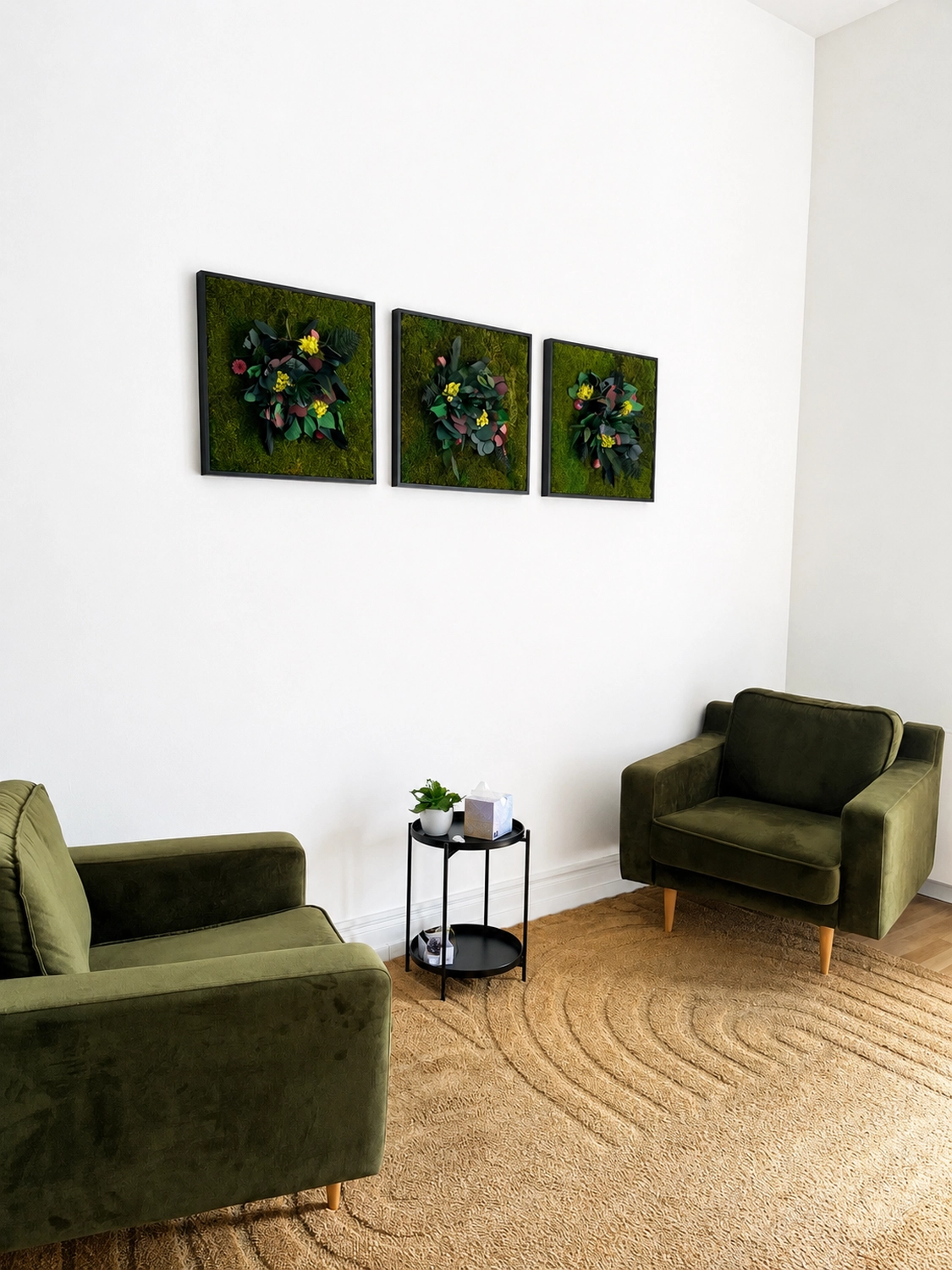 Bianca Sommer Psychotherapie – Ein gemütlicher, minimalistisch eingerichteter Raum mit zwei grauen Sesseln, die sich über einen kleinen runden Beistelltisch hinweg gegenüberstehen, drei dunklen Blumenbildern an der Wand und einem strukturierten Teppich unter sanftem violettem Licht.